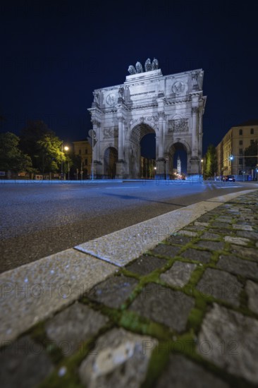 The illuminated Siegestor at night, focussed on the road surface, Siegestor, Munich, Germany