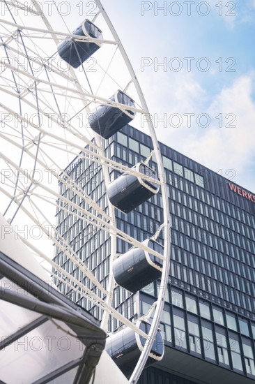 Close-up of a Ferris wheel next to a modern glass building, Werksviertel Munich, Munich, Germany