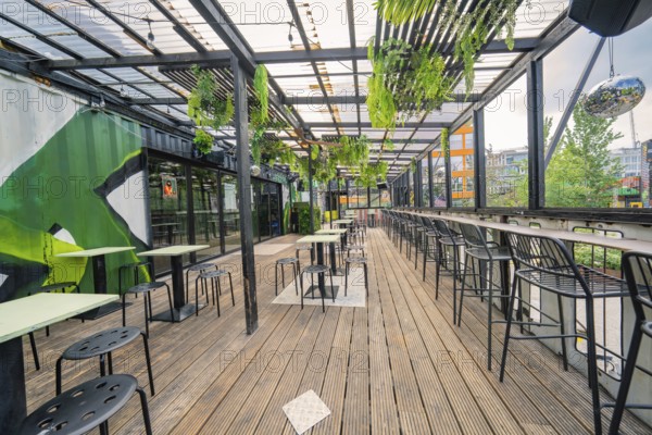 Modern industrial-style terrace with plants, bar and seating, Werksviertel Munich, Munich, Germany