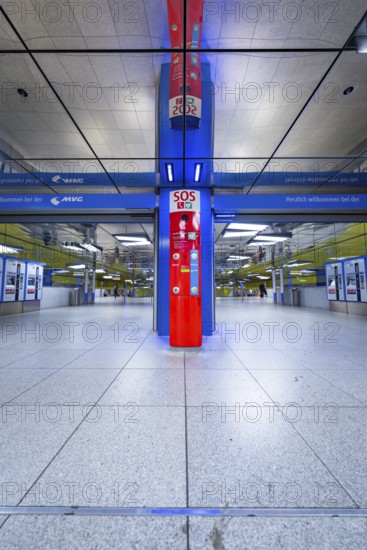 Modern underground station with blue and red elements and SOS station in Munich, Münchner Freiheit, Munich, Germany