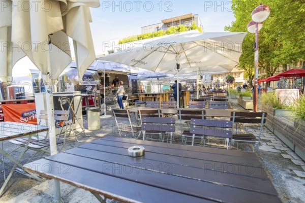 Empty outdoor café with tables and chairs under parasols, sunny and inviting, Sindelfingen, Böblingen district, Germany