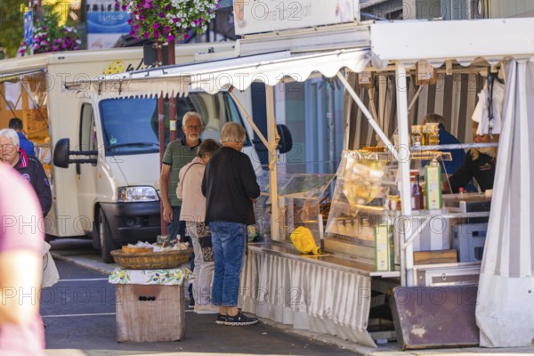 An open-air market stall offers fresh produce, with customers interacting, Sindelfingen, Böblingen district, Germany