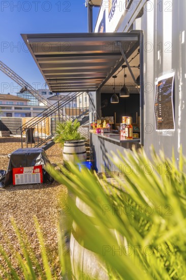 A modern snack stand in a container, surrounded by plants, in sunny weather, Sindelfingen, Böblingen district, Germany