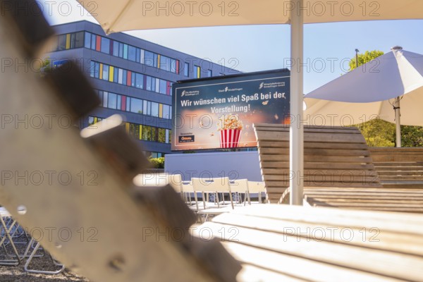 An urban outdoor area with chairs and a screen under parasols, open air cinema Sindelfingen, district of böblingen, Germany