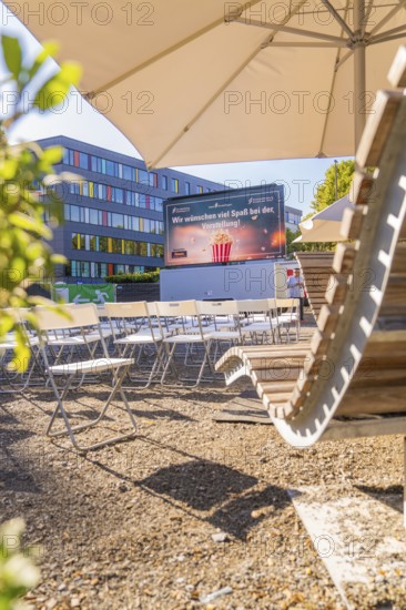 Seating and screen under parasols, sunny urban outdoor area, open air cinema Sindelfingen, district of böblingen, Germany