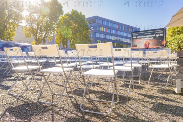 Rows of chairs outdoors under an umbrella in bright sunshine, open air cinema Sindelfingen, district of böblingen, Germany