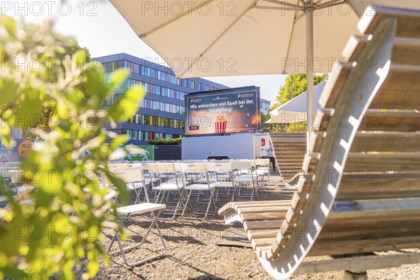 Rows of chairs under parasols in front of a screen, enlivened by sunshine, open air cinema Sindelfingen, district of böblingen, Germany
