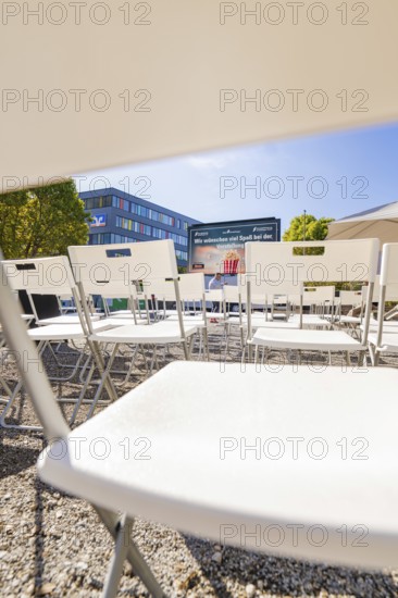 Rows of white chairs in front of an outdoor screen on a sunny day, open air cinema Sindelfingen, district of böblingen, Germany