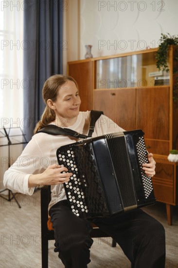 In a warm and inviting living room, a middle-aged woman skillfully plays the accordion, expressing her musical passion