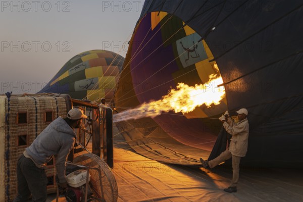 In order to get ready for the take-off, the pilot inflates the balloon with hot air by activating the burner. At dawn. Namib Desert, Kulala Wilderness Reserve, Namibia