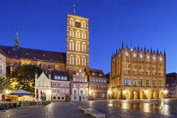 Night view, left back St. Nikolai Church first mentioned 1276, 102 metres high, front left, white, entrance Nikolaikirche, next to it Bürgehäuser, right town hall start of construction approx. 1300, secular building, brick Gothic, Alter Markt, Old Town, UNESCO World Heritage Site, Hanseatic City of Stralsund, Mecklenburg-Western Pomerania, Germany