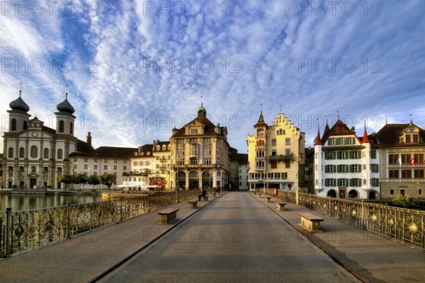 View of Lucerne's old town with Jesuit church from the Reuss bridge at sunrise, decorative cloudy atmosphere, Canton Lucerne, Switzerland