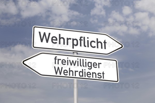 (Photomontage) Directional arrows pointing in the directions of MANDATORY DEFENCE and VOLUNTARY DEFENCE SERVICE