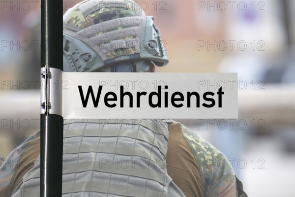 (Photomontage) Sign with text WEHRDIENST in front of a soldier