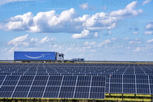 86, 5 MW peak ground-mounted photovoltaic systems, by RWE, with over 141, 000 solar modules, on a verge, over 1 km long, along the A44 motorway near Bedburg, at the Jackerath junction, recultivated open-cast mining site, field with sunflowers, North Rhine-Westphalia, Germany