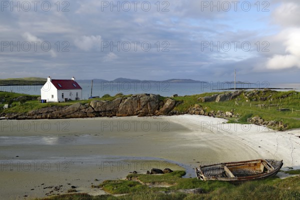 A lonely house and an old boat on a quiet, rocky beach, Isle of Barra, Hebrides, Scotland, United Kingdom