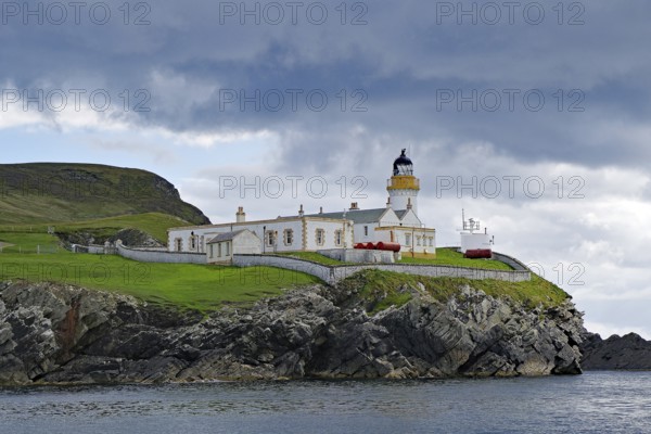 A lighthouse stands on a grassy cliff on a cloudy day, Robert Louis Stevensen, Isle of Noss, Shetland Islands, Scotland, Great Britain