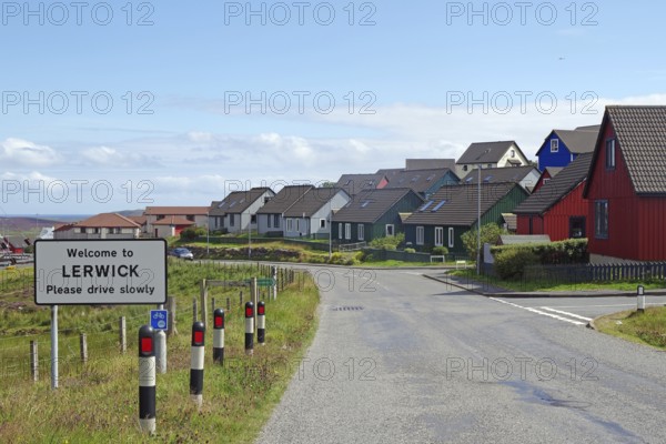 Colourful houses line a street with a welcome sign in a town, Lerwick, Shetland Islands, Scotland, United Kingdom