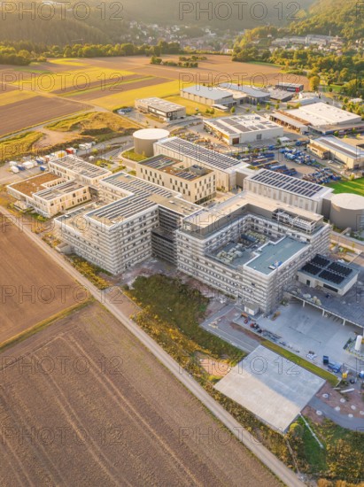 Extensive modern building surrounded by fields, in rural dusk, new hospital building, Calw health campus, Black Forest, Germany