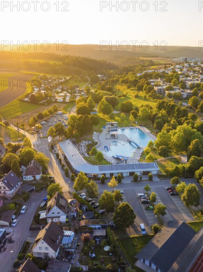 Leisure area with swimming pool and trees in a housing estate at sunset, small town of Perle Calw, Black Forest, Germany