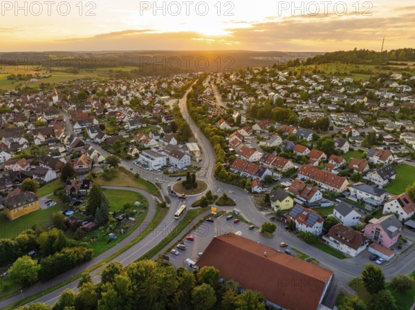 Sea of houses with curved streets in warm sunset light and green surroundings, small town of Perle Calw, Black Forest, Germany