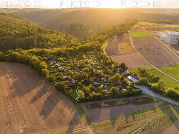 Campsite between forests and fields at sunset with rolling hills, small town Perle Calw, Black Forest, Germany