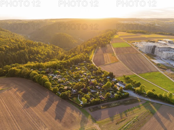 Campsite on the edge of a forest with farmland in the warm light of the setting sun, small town of Perle Calw, Black Forest, Germany