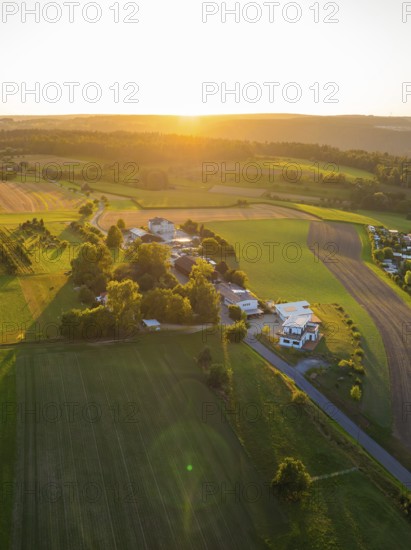 Idyllic landscape with fields and buildings in the warm light of the sunset, small town of Perle Calw, Black Forest, Germany