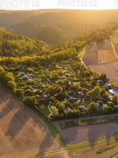 CampsiteIdyllic village landscape with fields and forest in the evening sun, surrounded by rolling hills, small town of Perle Calw, Black Forest, Germany
