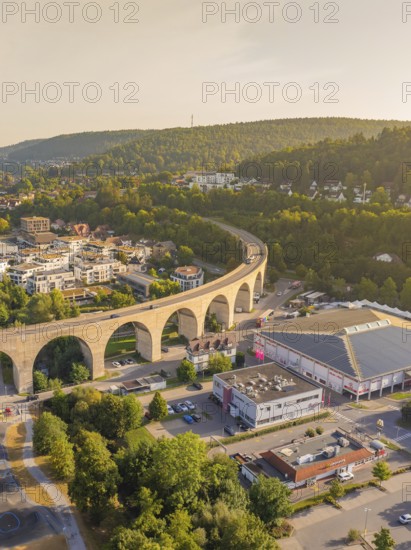 Imposing viaduct over a town with surrounding hills and forest at dusk, small town Perle Nagold, Black Forest, Germany