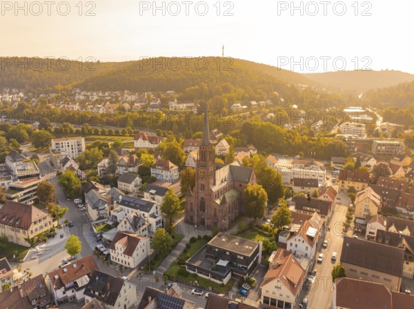 Small town with central church and surrounding hills seen from above in the warm evening light, small town pearl Nagold, Black Forest, Germany
