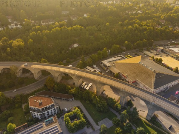 Viaduct in the evening light, passing through an urban and wooded landscape and illuminated at sunset, small town of Perle Nagold, Black Forest, Germany