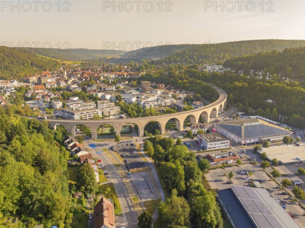 Large viaduct leading over a town and through a hilly landscape, shown from the air, small town of Perle Nagold, Black Forest, Germany