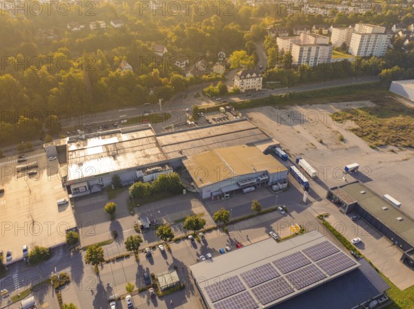 Wide view of an industrial area with car parks and solar panels on the roofs, small town of Perle Nagold, Black Forest, Germany