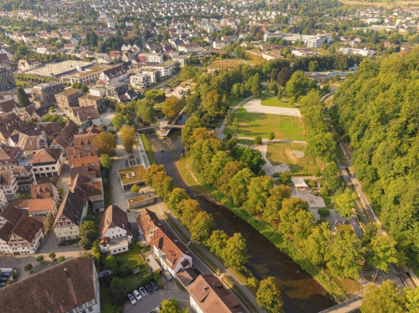 Aerial view of town with river and parkland next to urban development, small town of Perle Nagold, Black Forest, Germany