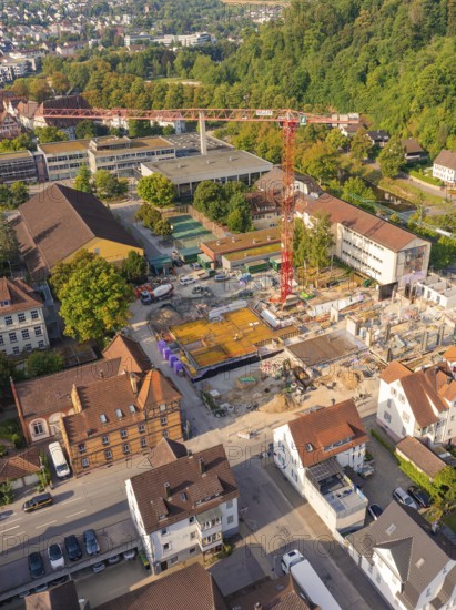 Construction site in the middle of an urban environment with crane and surrounding building structures, small town of Perle Nagold, Black Forest, Germany