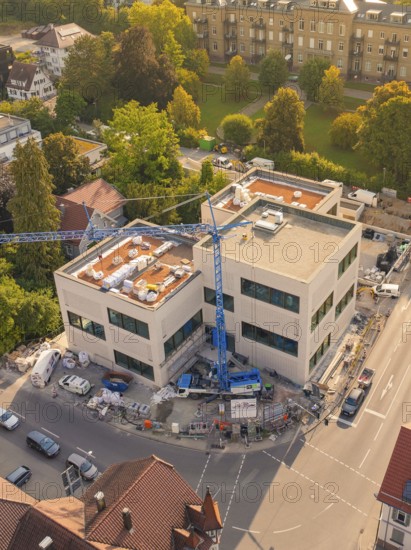 Large modern building under construction with a crane surrounded by an urban environment, small town of Perle Nagold, Black Forest, Germany