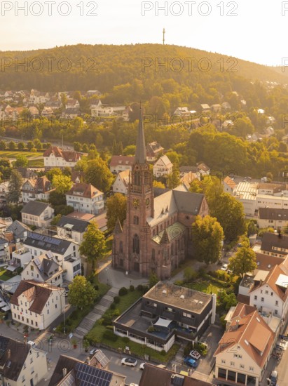 Church in the centre of a small town with a hill in the background, warm golden light envelops the town, small town pearl Nagold, Black Forest, Germany
