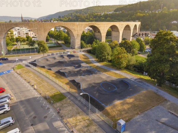 Pump track under a large bridge, surrounded by nature and urban architecture, pump track, Nagold, Black Forest, Germany