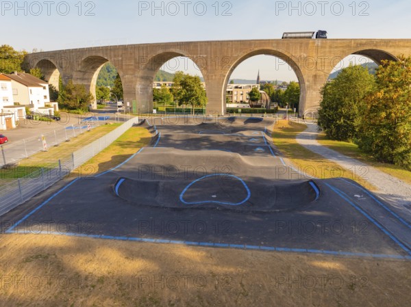 Pump track with asphalt under a large bridge in a green environment, pump track, Nagold, Black Forest, Germany