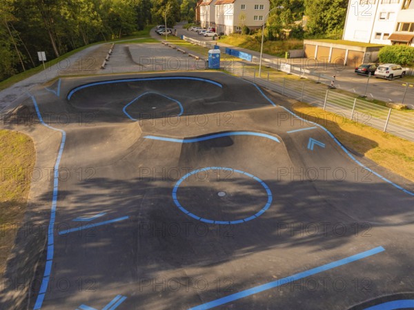 A pump track marked with blue lines in a green, urban environment, pump track, Nagold, Black Forest, Germany