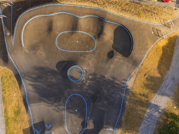 Pump track with blue lines seen from the air, surrounded by shadows and asphalt, pump track, Nagold, Black Forest, Germany