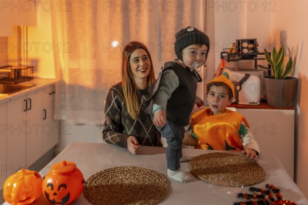 Mother and children enjoying halloween costumes, playing and laughing together in the cozy kitchen, creating joyful memories at home