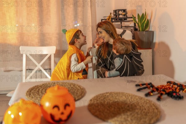 Mother and children wearing halloween costumes, enjoying time together at home, surrounded by festive decorations
