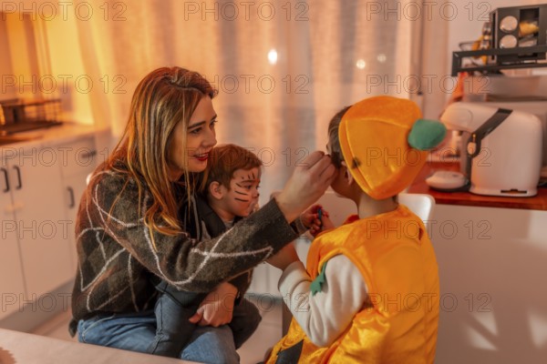 Mom applying makeup on her kids, joyfully preparing costumes for halloween night, creating fun memories in a warm, cozy kitchen