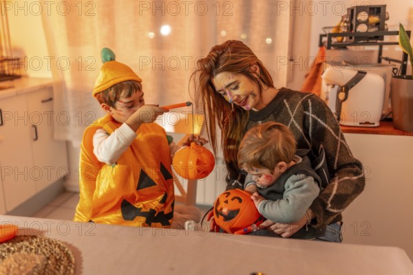 Children and mother painting halloween pumpkins, wearing costumes, and making decorations at home