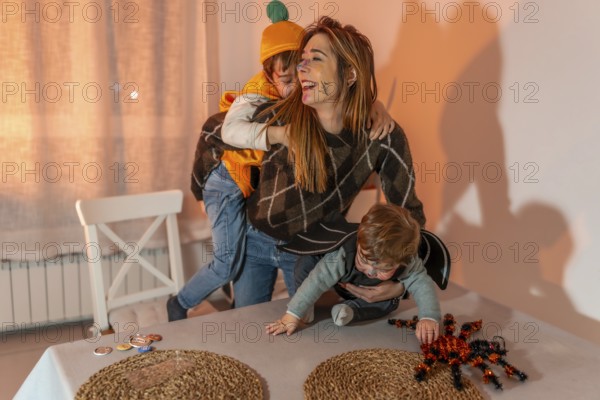 Happy family enjoying halloween festivities, wearing colorful costumes and playing joyfully together in a decorated dining room