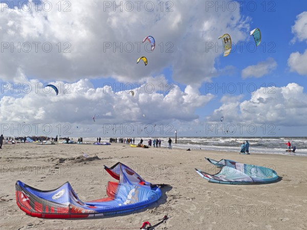 California kitesurfing Masters 2025 at the edge of the UNESCO World Heritage Wadden Sea, North Sea, kitesurfing sport, flying kites, spectators, fun, competition, strong wind, whitecaps, beach, summer, sunshine, blue sky, white clouds, Ording, Sankt Peter-Ording, Schleswig-Holstein, Germany