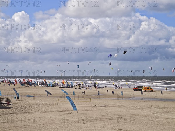 California kitesurfing Masters 2025 on the edge of the Wadden Sea UNESCO World Heritage Site, North Sea, kitesurfing sport, flying kites, fun, competition, strong wind, whitecaps, beach, summer, sunshine, blue sky, white clouds, ambulance, Ording, Sankt Peter-Ording, Schleswig-Holstein, Germany