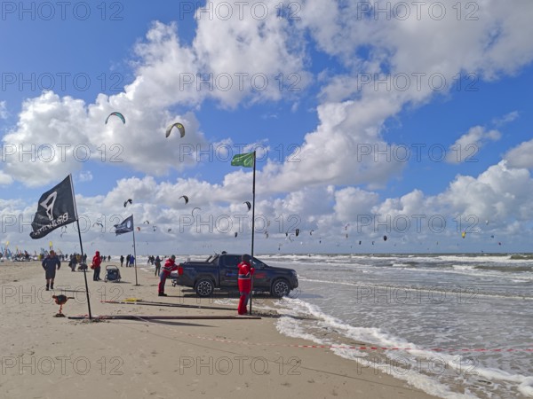 California kitesurfing Masters 2025, kitesurfing on the North Sea beach on the edge of the UNESCO World Heritage Wadden Sea, sports competition, car, flags, strong wind, high swell, whitecaps, summer, sun, blue sky, white clouds, Ording, Sankt Peter-Ording, Schleswig-Holstein, Germany